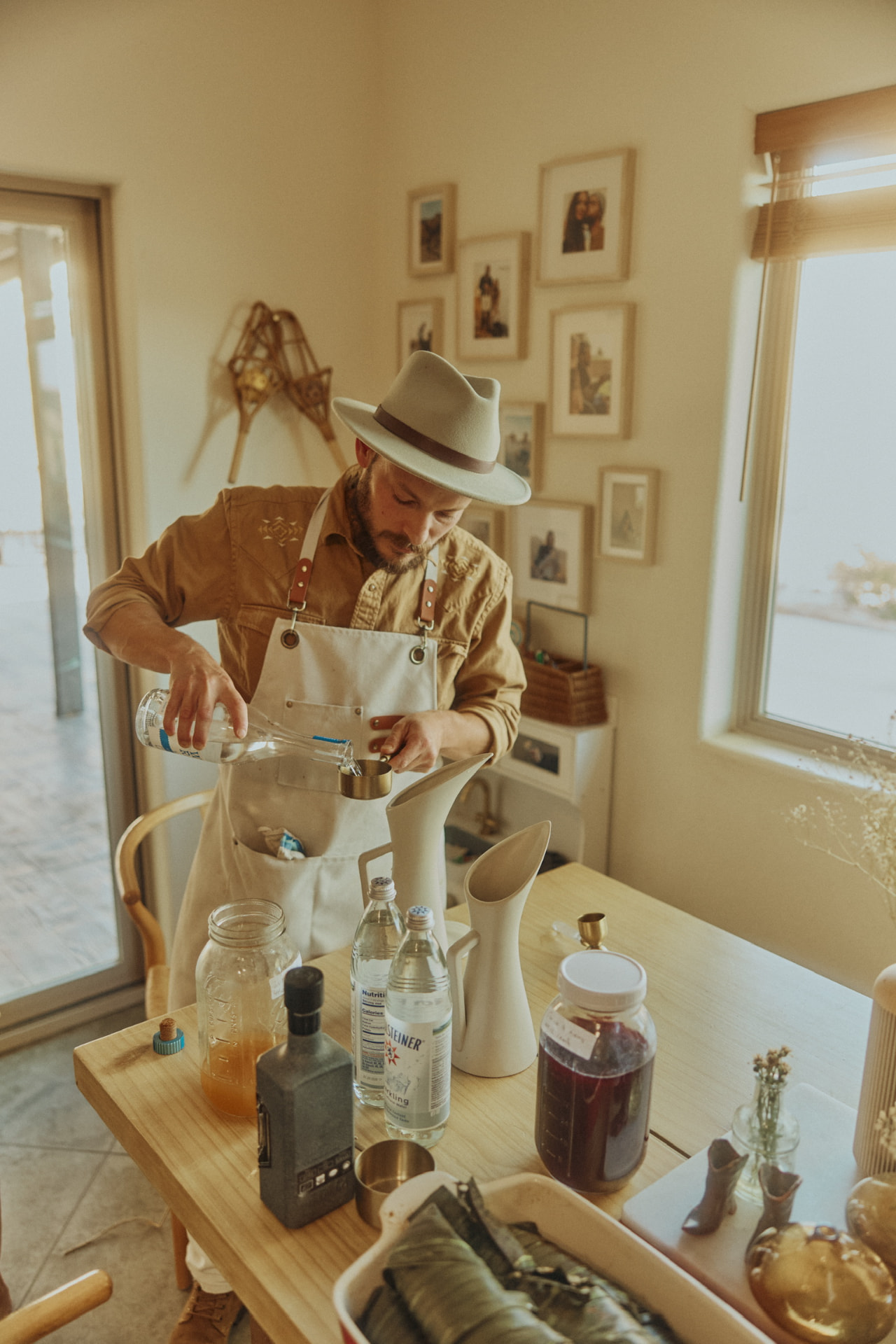 Chef Daniel mixing a batched cocktail at a sunlit table
